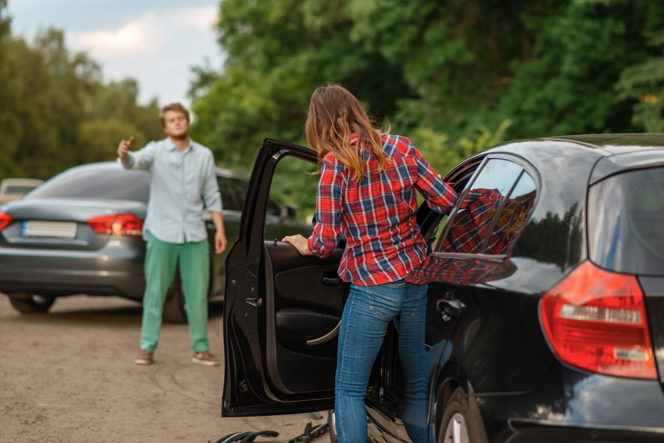 Male and female drivers after car accident on road