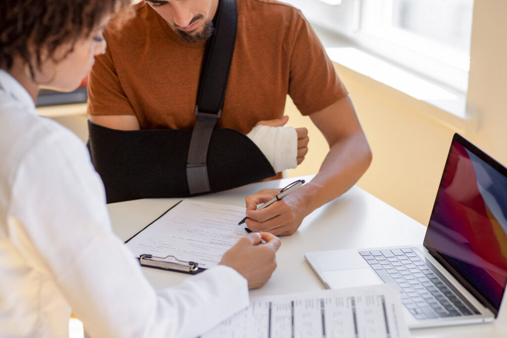 Doctor and patient sit and talk. Filling medical insurance form
